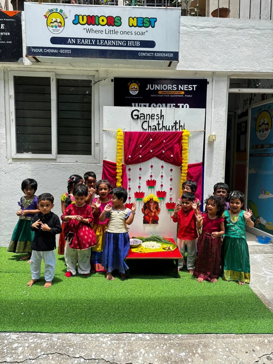 Children dressed in traditional clothing celebrating Vinayagar Chaturthi in front of decorated stage