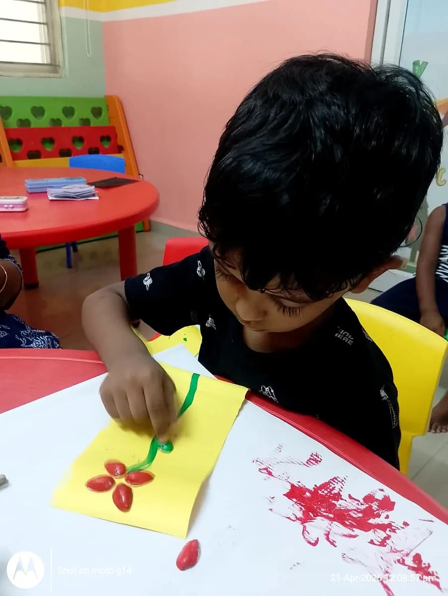 Child patiently sticking seashells onto art sheet to create flower design
